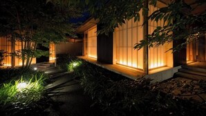 Een traditioneel Japans gebouw met schuifdeuren en een goed verlicht pad.