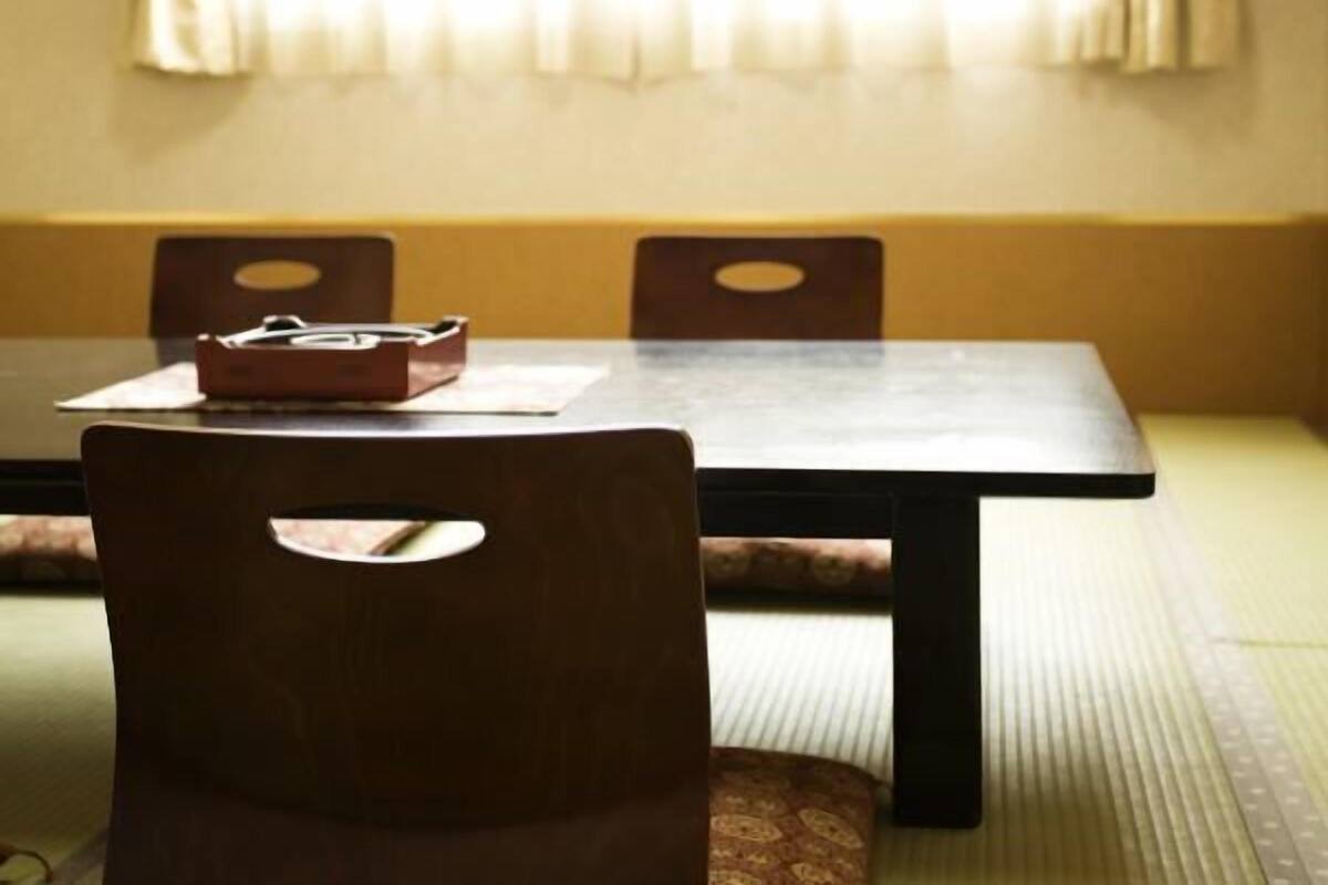 A dining table with chairs, a cushion, and a small wooden box on the table.