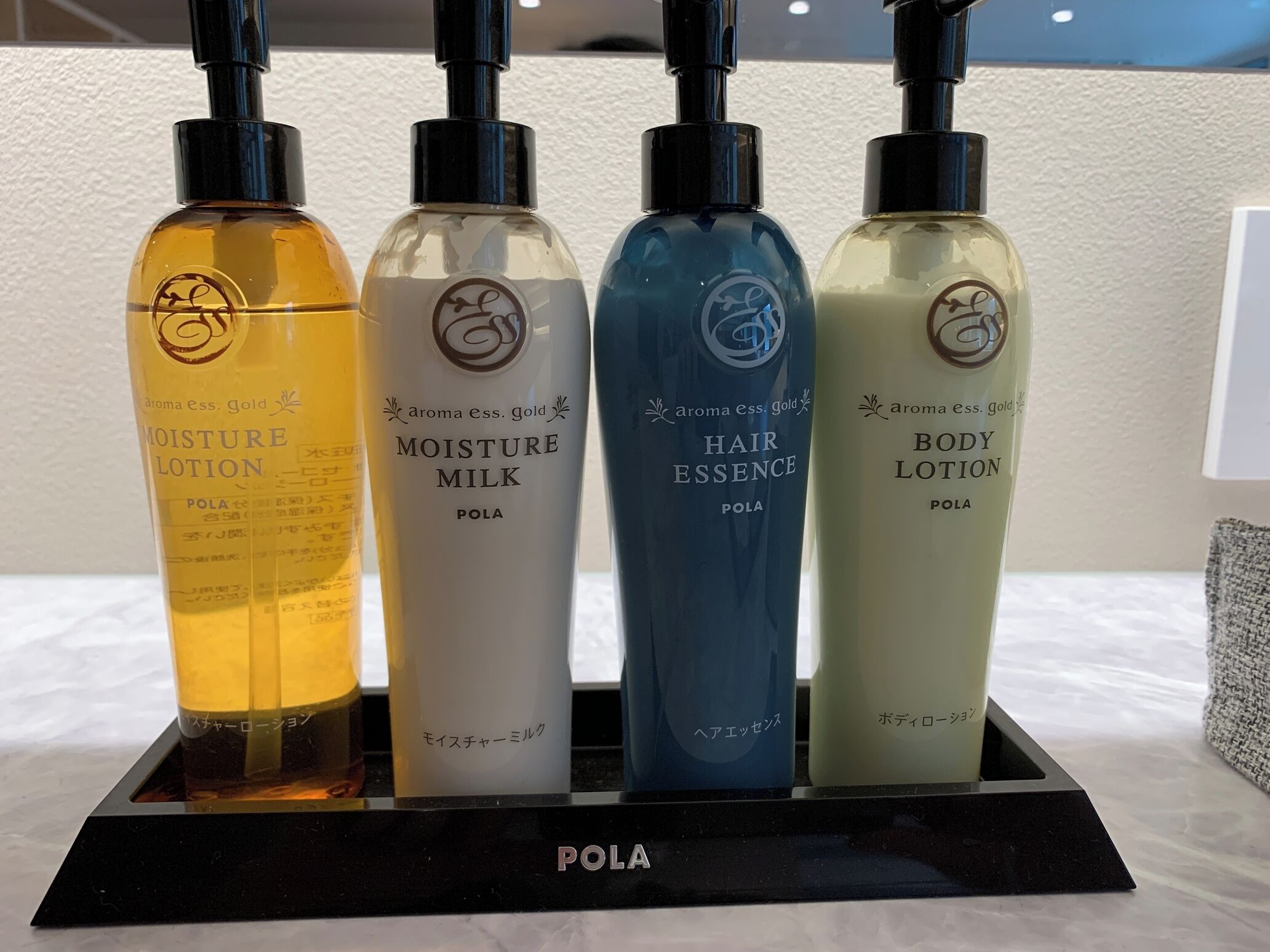 Four bottles of POLA products on a black display stand.
