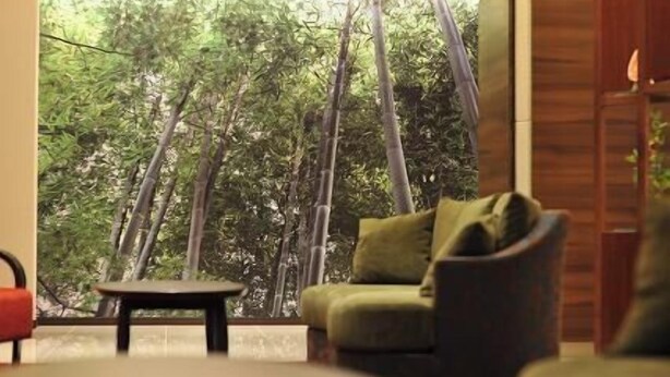 A room with a large window, a sofa, and a small table. - Marugame Plaza Hotel (Marugame)