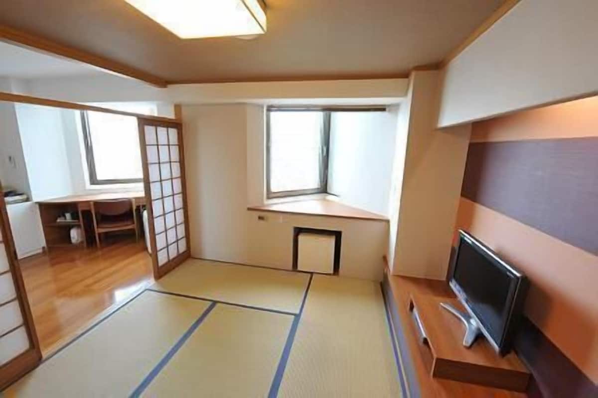 Habitació amb terra de tatami, televisió, escriptori i finestra.