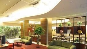 A modern lounge area with seating, a coffee table, and a television. - Marugame Plaza Hotel (Marugame)
