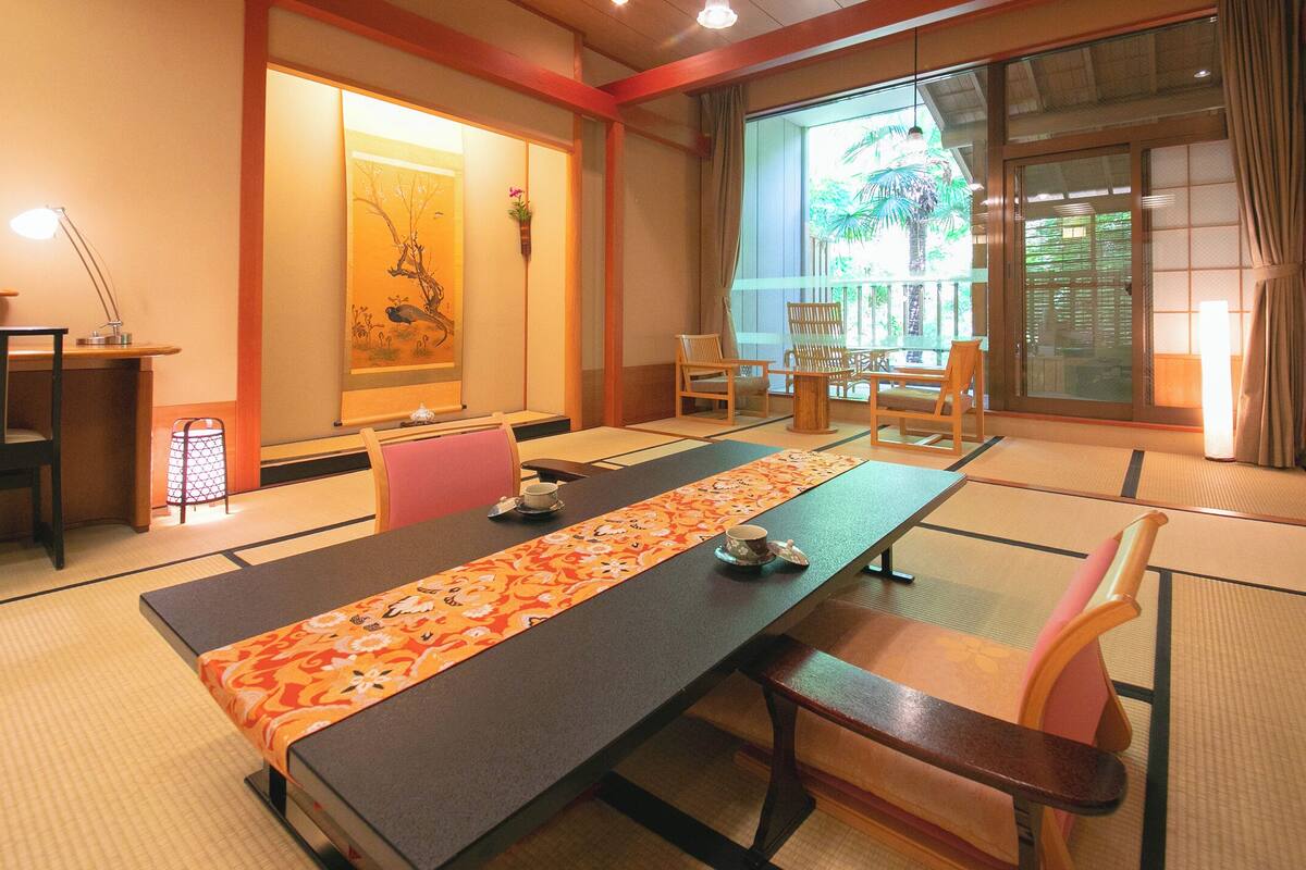 Une pièce de style japonais traditionnel, avec un sol recouvert de tatamis, une table basse et une porte coulissante.