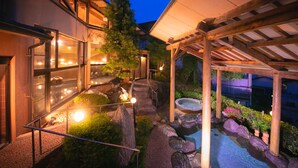 Un espace extérieur bien éclairé, doté d’un jacuzzi, d’un chemin en pierre et d’une pergola.