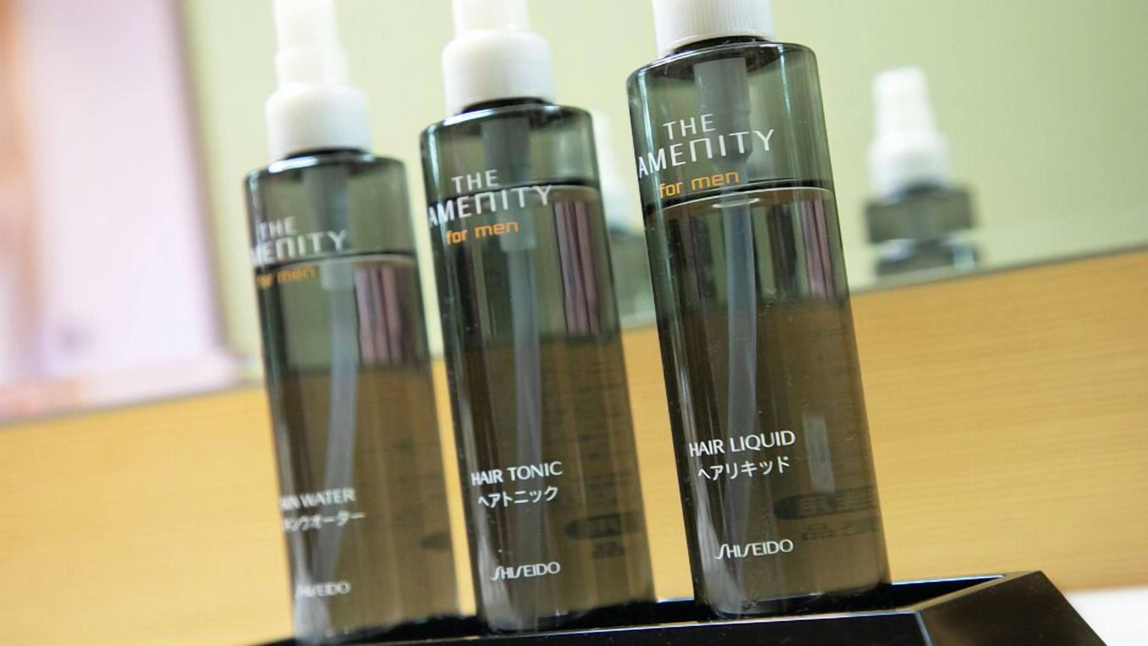 Three bottles of hair tonic on a black stand.