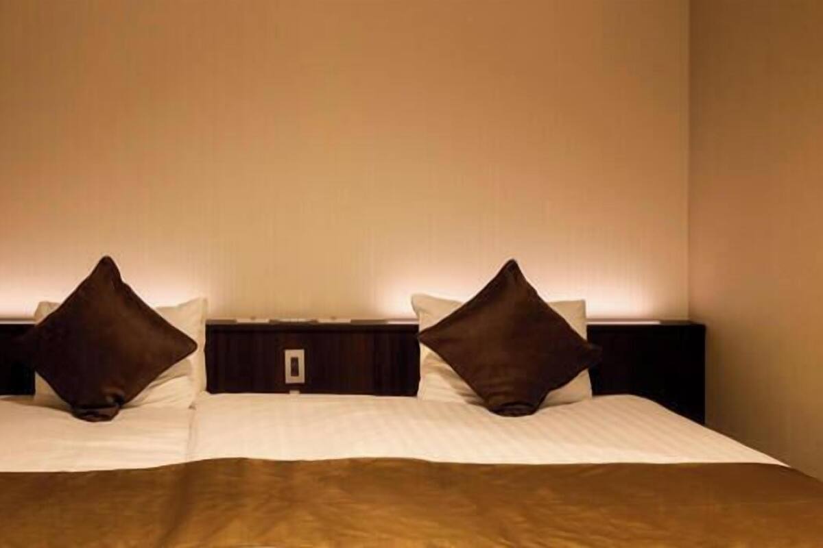 Ein Hotelzimmer mit einem Bett, zwei Nachttischen und einer Wandleuchte.