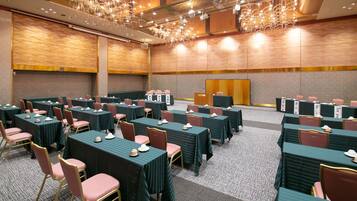 A conference room with rows of tables and chairs, equipped with nameplates and table settings.
