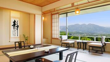 A traditional Japanese-style meeting room with tatami flooring, a long table, and chairs.