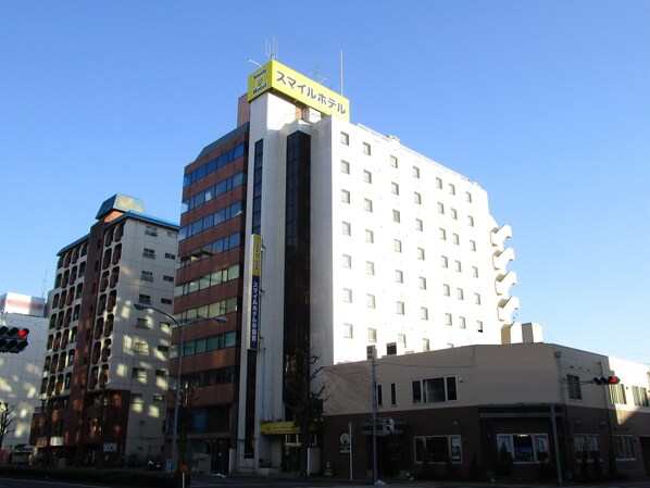 Un hôtel à plusieurs étages, reconnaissable à son grand panneau jaune situé en haut, à sa vaste façade vitrée et à son architecture moderne.