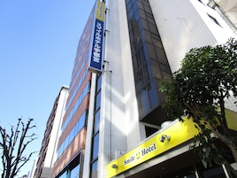Um edifício com uma placa indicando Smile Hotel e outra placa para um estabelecimento comercial.