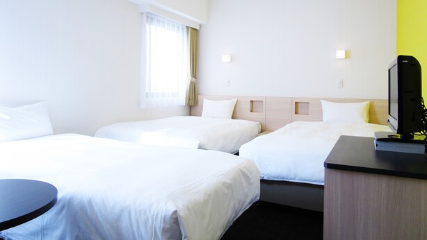 A hotel room with two beds, a desk, a television, and a window with curtains. - Smile Hotel - Utsunomiya Higashiguchi (Utsunomiya)