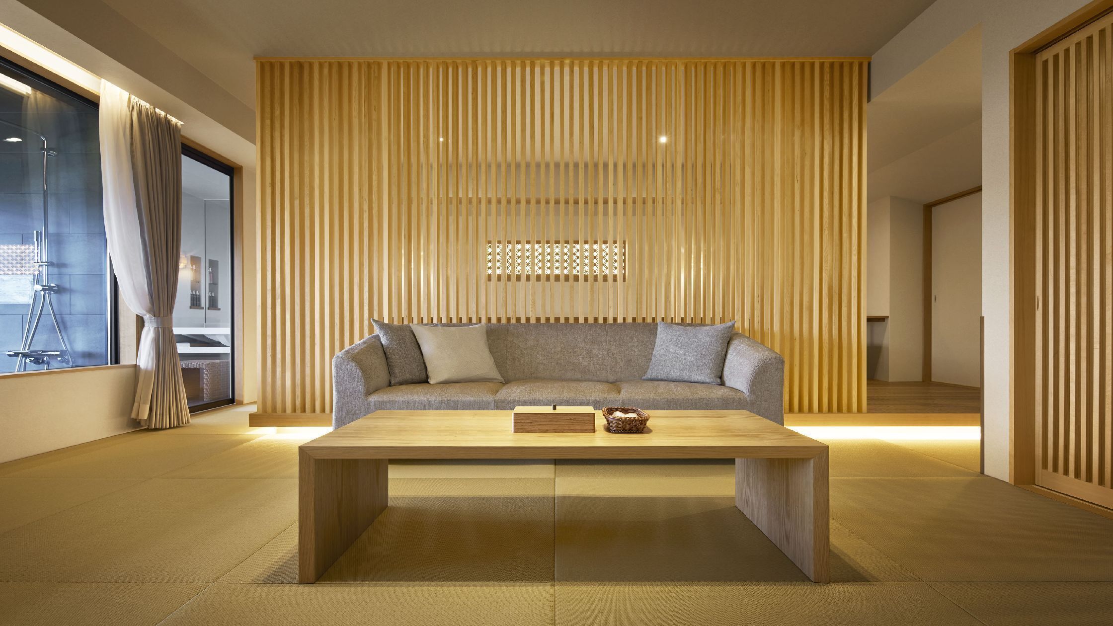 A modern living room with a sofa, a wooden coffee table, and a sliding wooden partition.