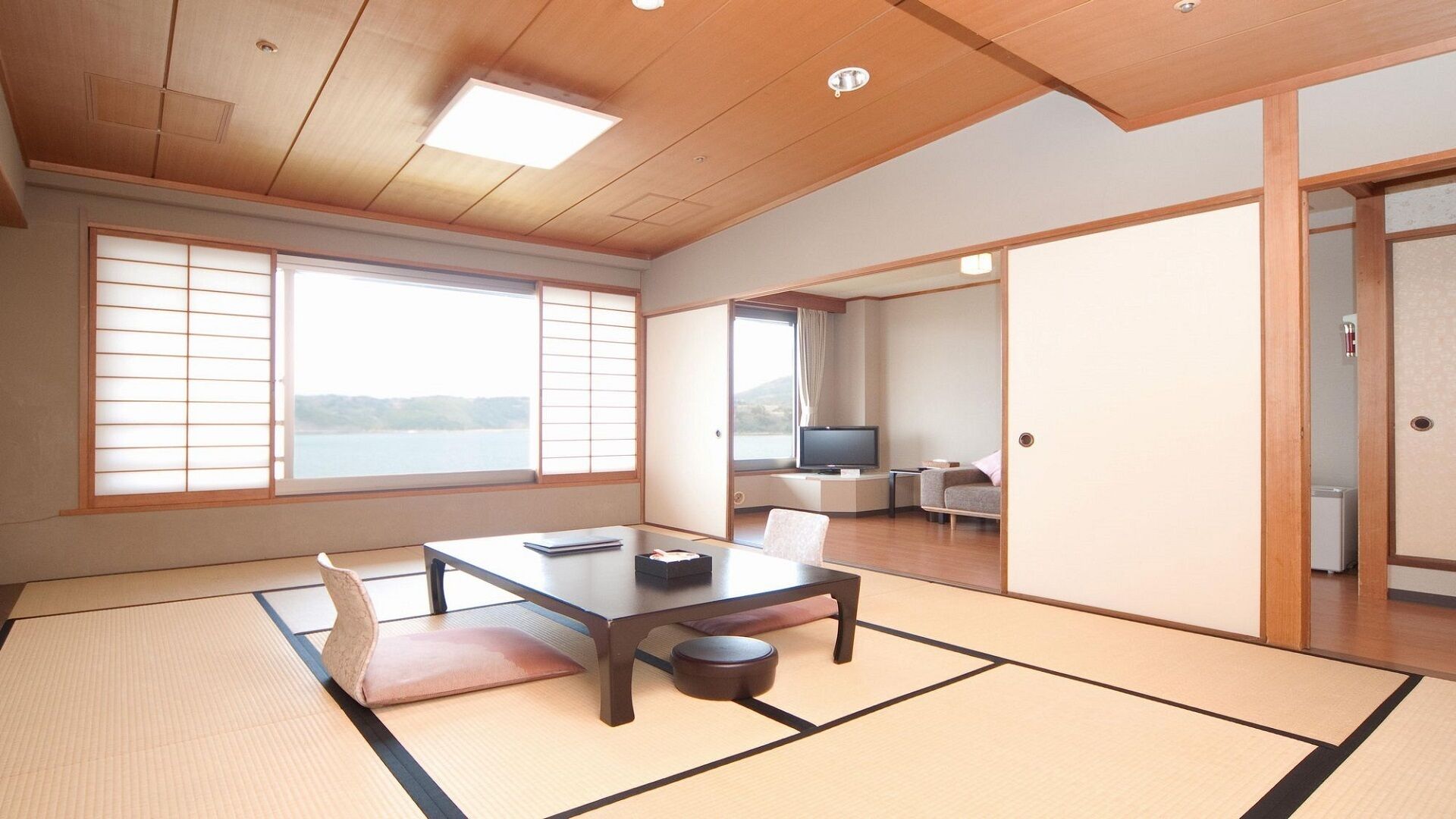 A traditional Japanese room with tatami flooring, a low table, and sliding doors.