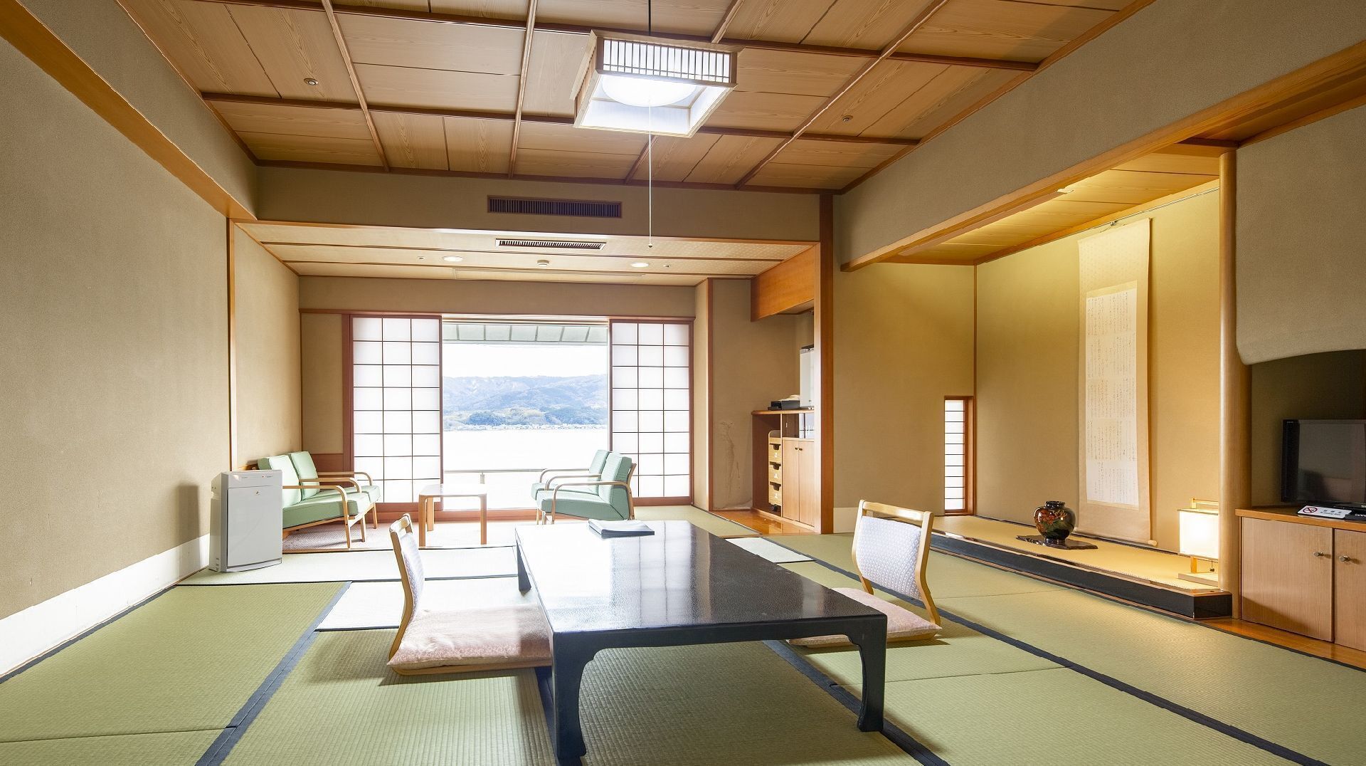 A traditional Japanese room with tatami flooring, a low table, and sliding doors.