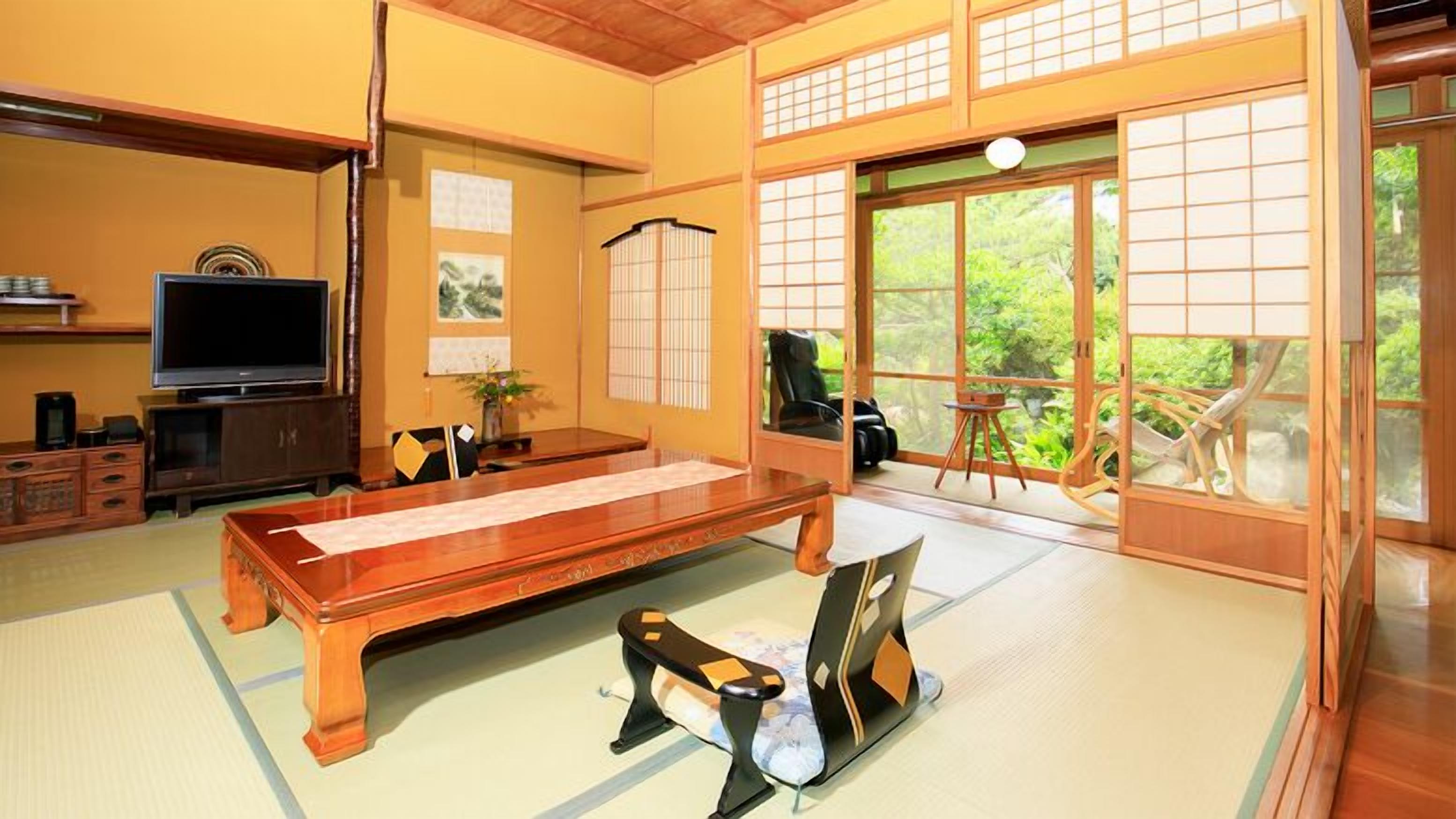A tatami mat room with a tatami mat table, a television, and sliding doors leading to a balcony.