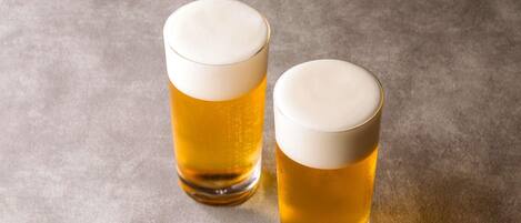 Two glasses of beer on a textured surface.
