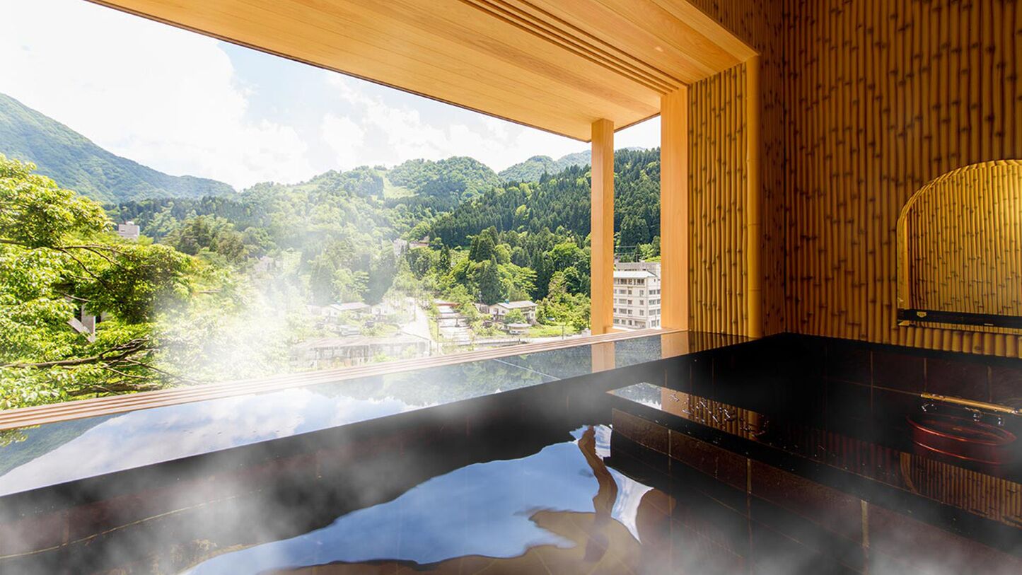 A spa area with a hot tub, wooden ceiling, and a view of a mountainous landscape.