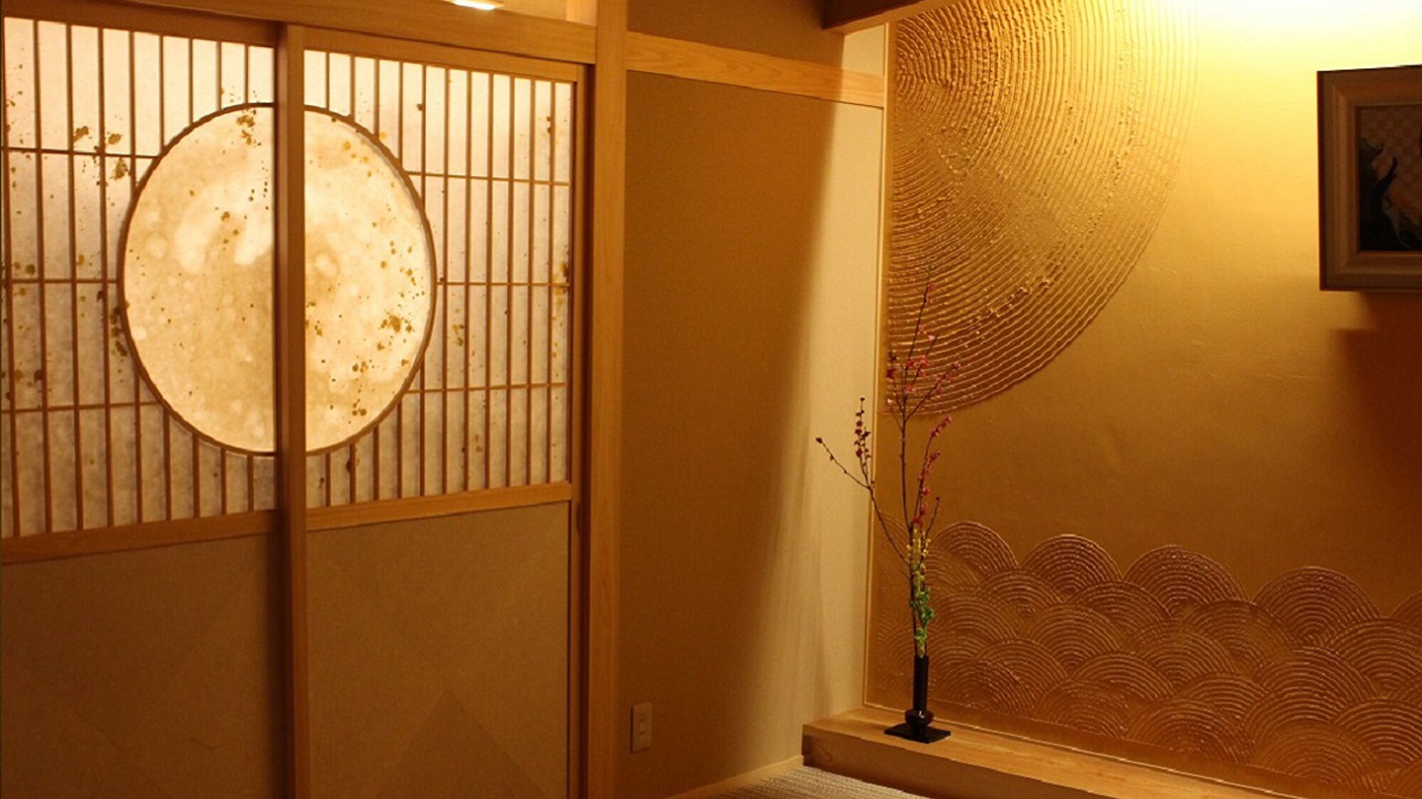 A traditional Japanese room with sliding doors, a decorative wall, and a small table with a vase.