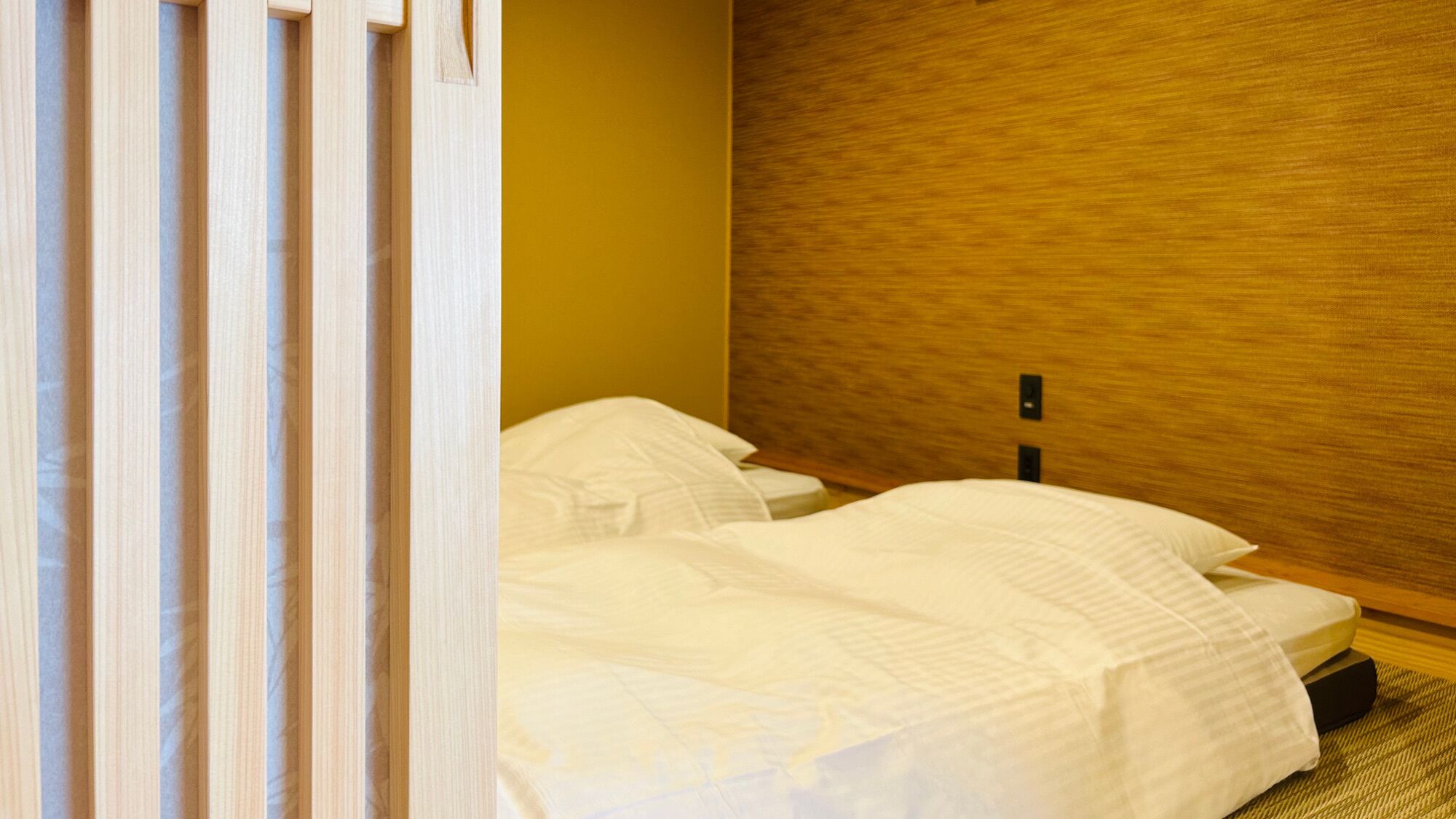 A hotel room with two beds, a wooden headboard, and a striped curtain.