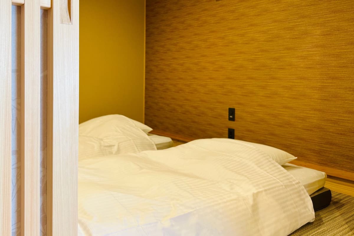 A hotel room with two beds, a wooden headboard, and a striped curtain.