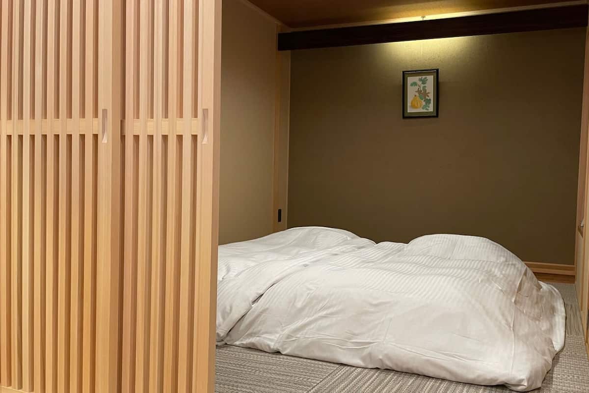 Ein Zimmer mit einem Bett, einer Holzhakepartition und einem gerahmten Bild an der Wand.