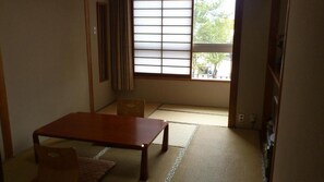 A traditional Japanese room with tatami flooring, a low wooden table, and a sliding shoji screen. - Yamaichi Bekkan (Hatsukaichi)