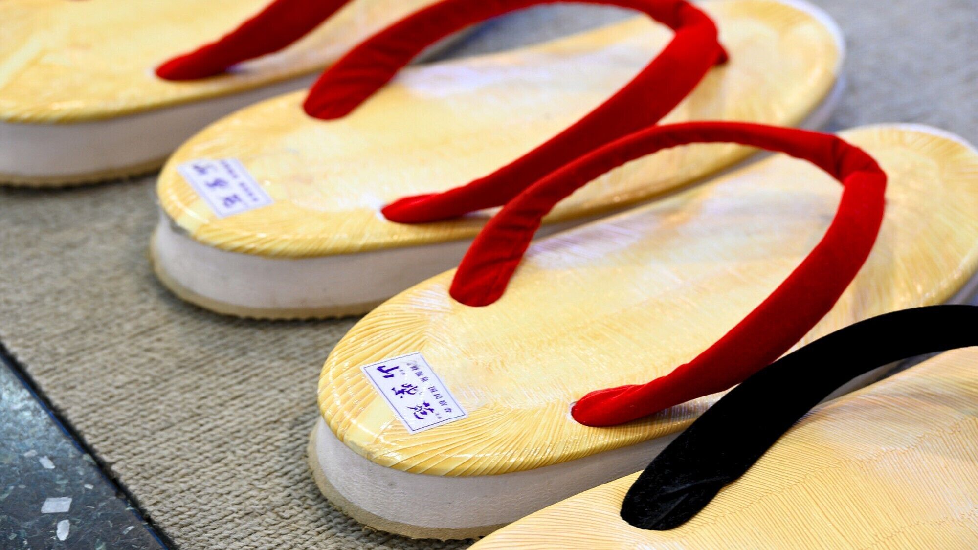 Un par de chanclas con correas rojas y una etiqueta de precio.