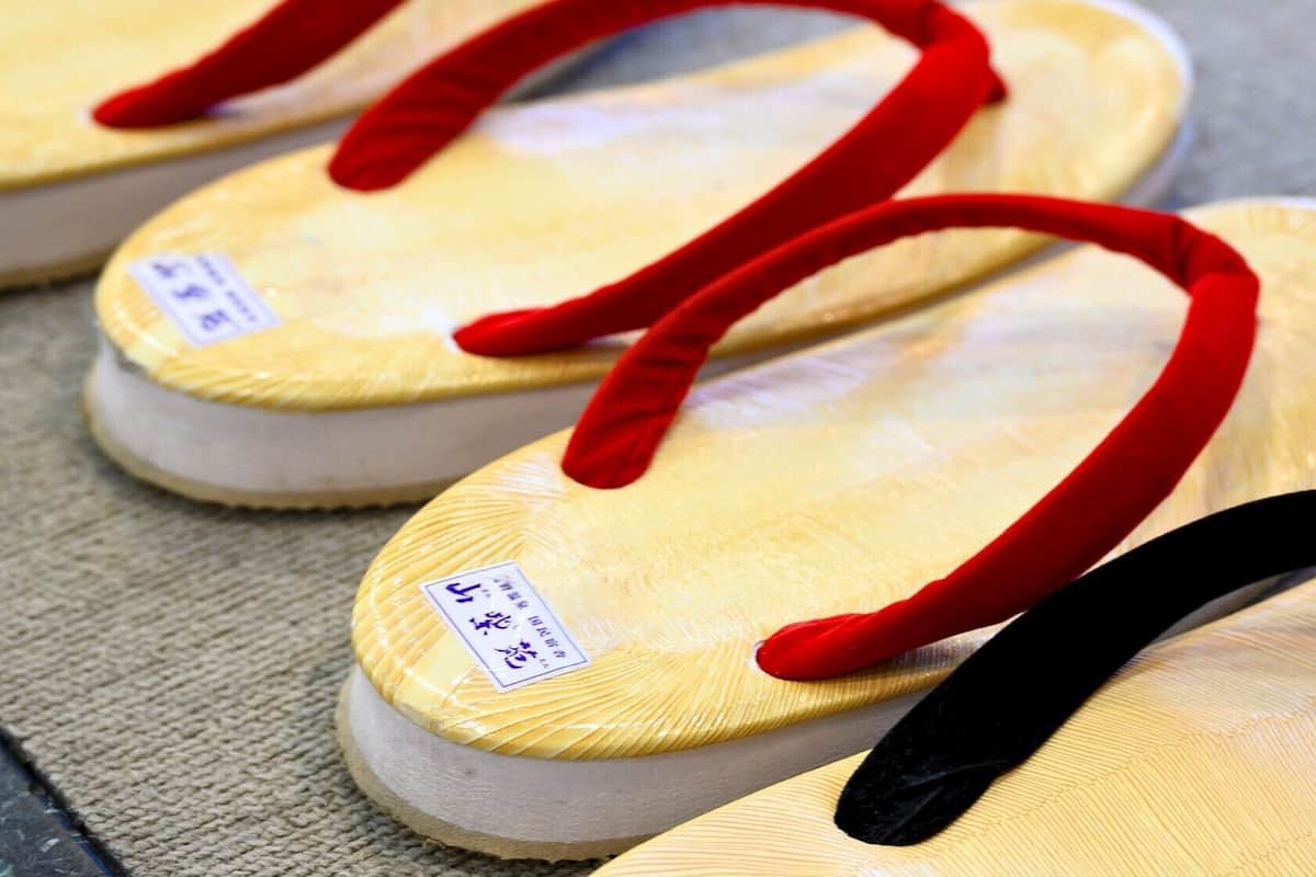 A pair of flip-flops with red straps and a price tag.