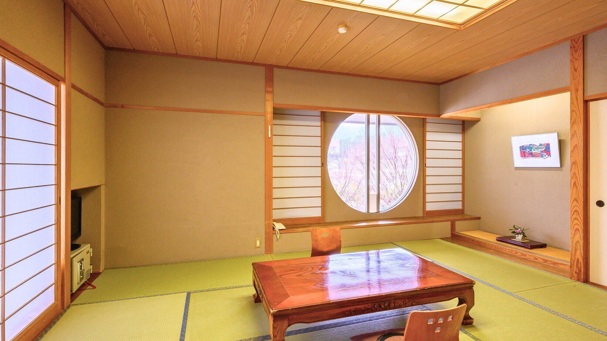 Una habitación japonesa tradicional con suelo de tatami, una mesa de madera y puertas correderas shoji.