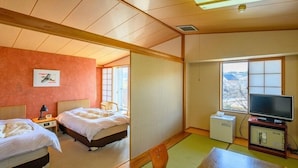 Quarto de hotel com duas camas, televisão, mesa pequena e janela com vista.