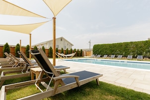 Una piscina al aire libre de temporada, sillones reclinables de piscina
