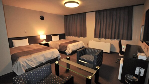 A hotel room with two beds, a desk, a chair, a TV, and a window with curtains. - Kokusai Daiichi Hotel (Oyama)