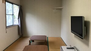 A room with tatami flooring, a bed, a desk, a television, and a heater. - Hotel Famitic Myojin (Nikko)