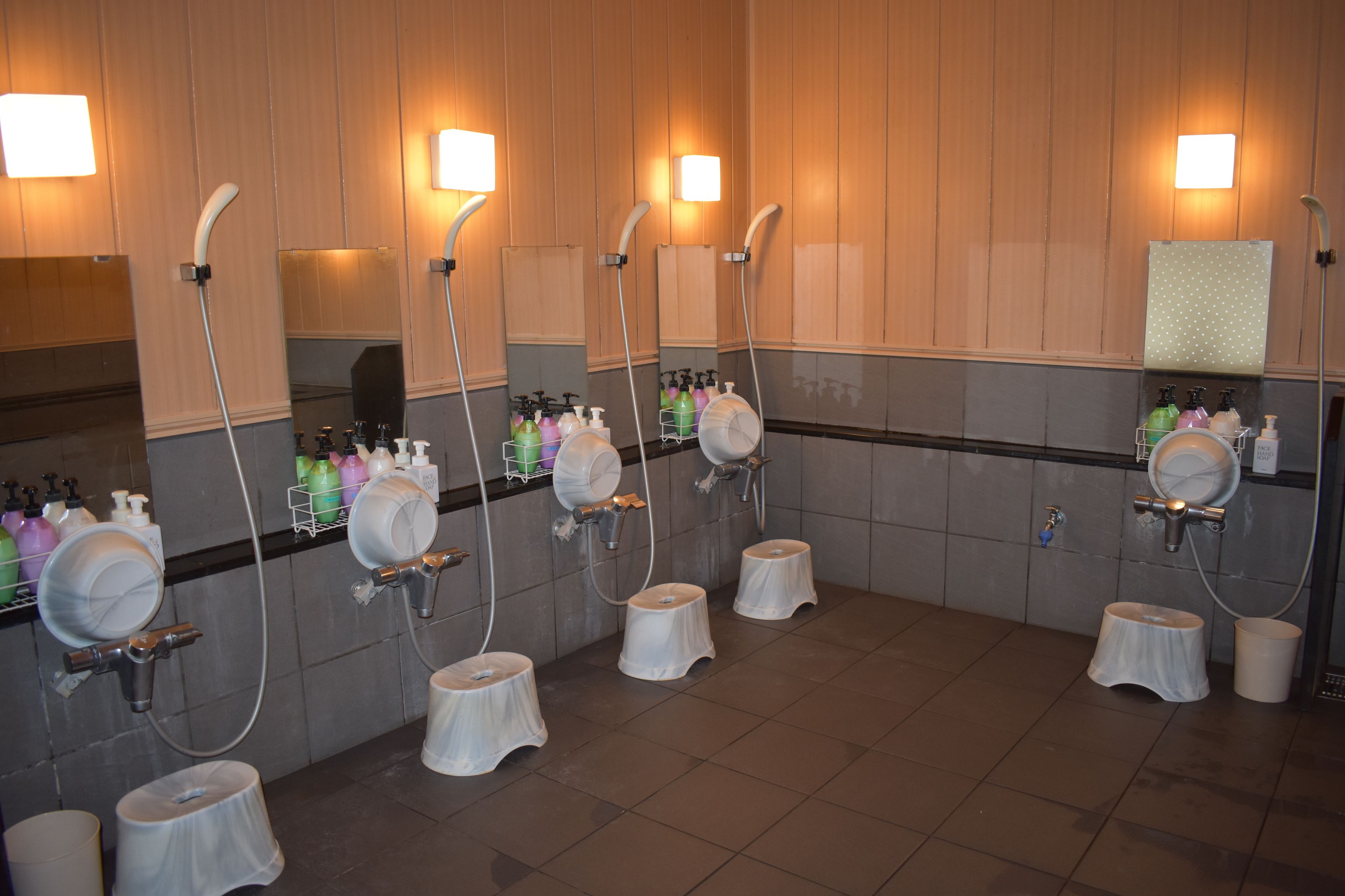 A public restroom with multiple sinks, mirrors, and hand dryers.