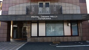 The exterior of Hotel Crown Hills in Toyokawa, featuring a modern facade with a prominent entrance and a balcony with decorative railings. - Hotel Crown Hills Toyokawa (Toyokawa)
