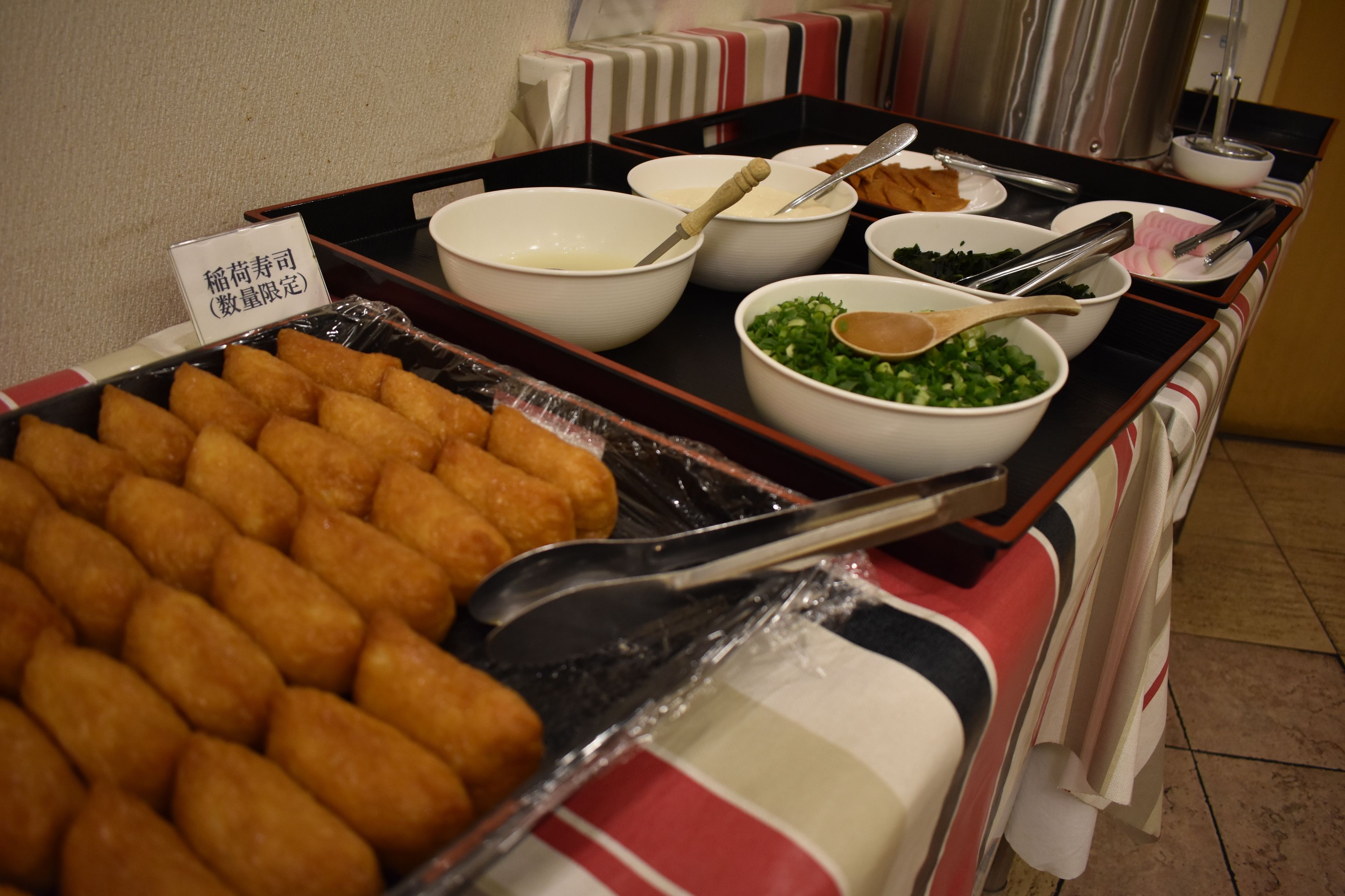 Ein Buffet mit verschiedenen Speisen, darunter eine Auswahl an frittierten Snacks sowie mehrere Schalen mit Saucen und Garnituren.