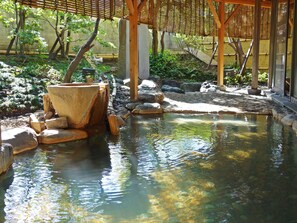 A traditional Japanese garden with a koi pond, bamboo structures, and stone lanterns. - Kansuitei Kozeniya (Tottori)