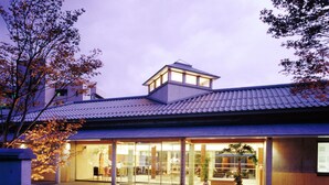 A modern building with a tiled roof and large glass windows. - Kansuitei Kozeniya (Tottori)