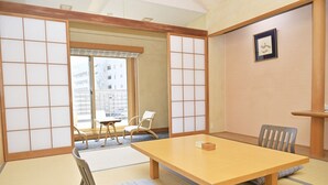 A traditional Japanese room with tatami flooring, a low table, and sliding doors. - Kansuitei Kozeniya (Tottori)
