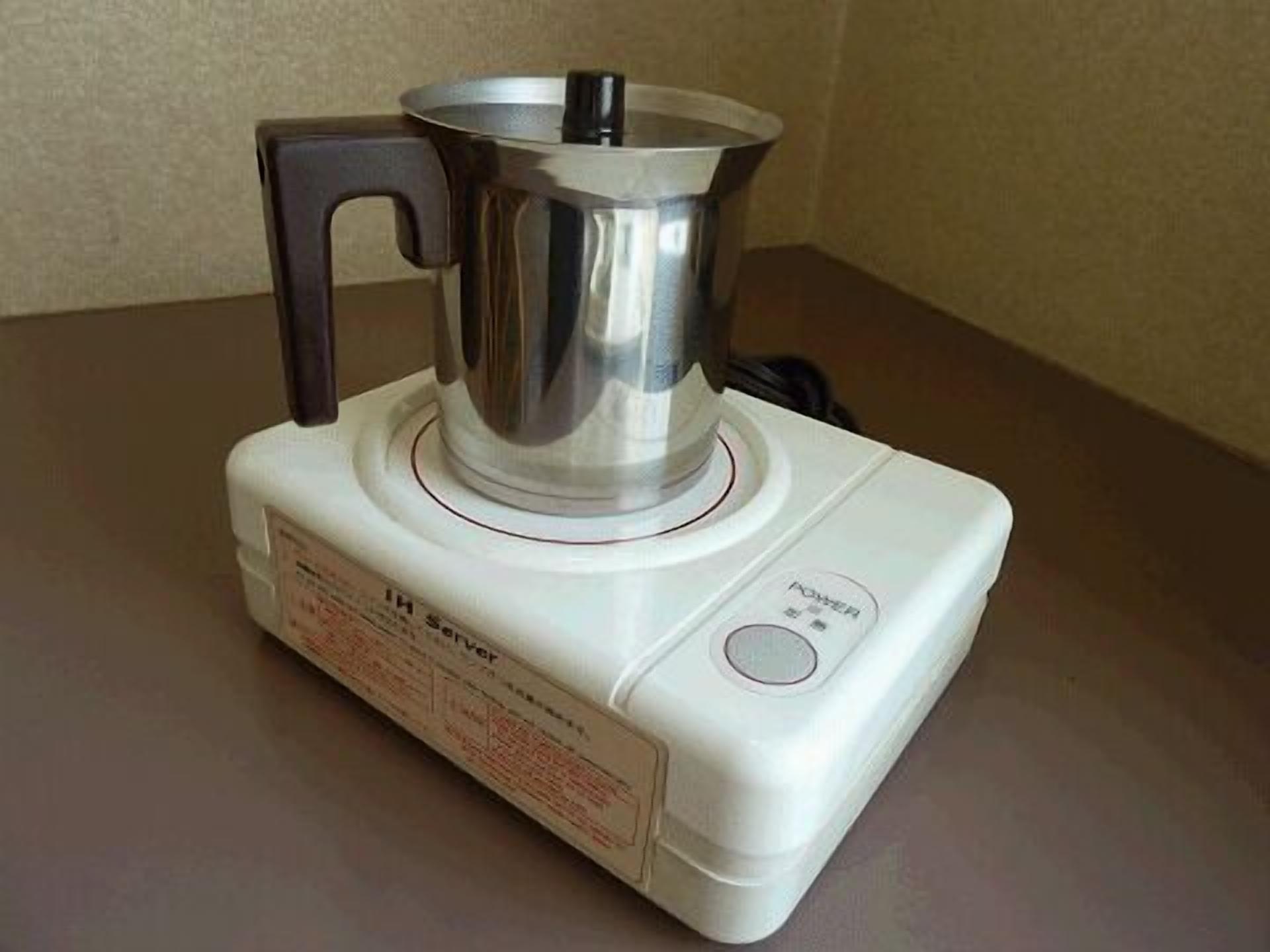 Una tetera eléctrica portátil con un botón de encendido y un panel de control.