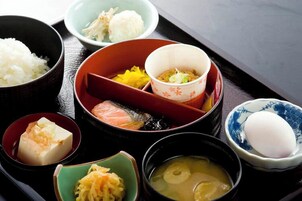 Una comida tradicional japonesa con arroz, pescado, tofu y sopa.