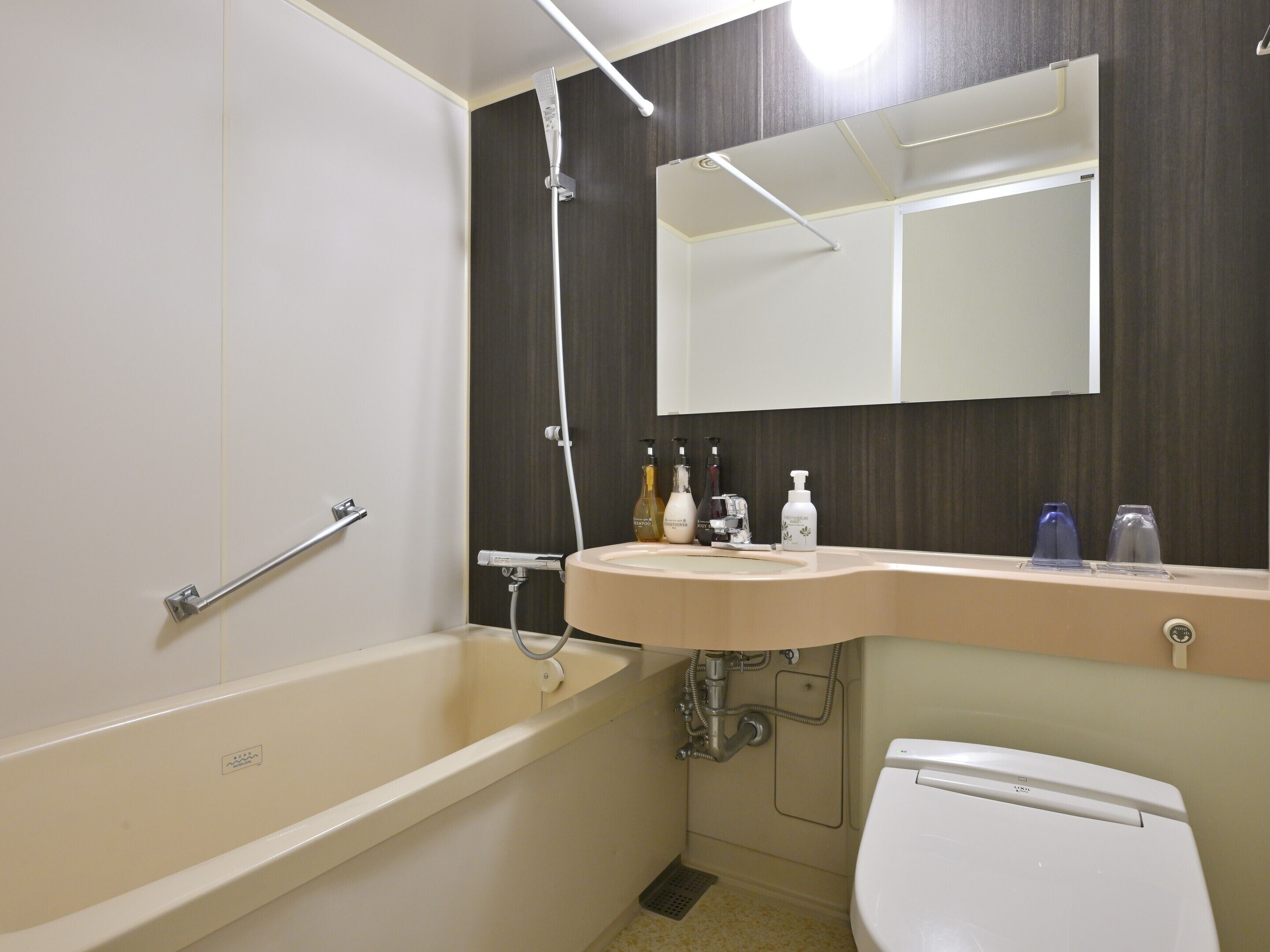 A bathroom with a bathtub, a sink, a toilet, and a mirror.