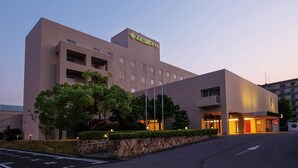 A modern hotel with a flat roof, multiple floors, and a sign indicating it is a high school international hotel.