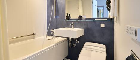 A modern bathroom with a bathtub, toilet, and sink.