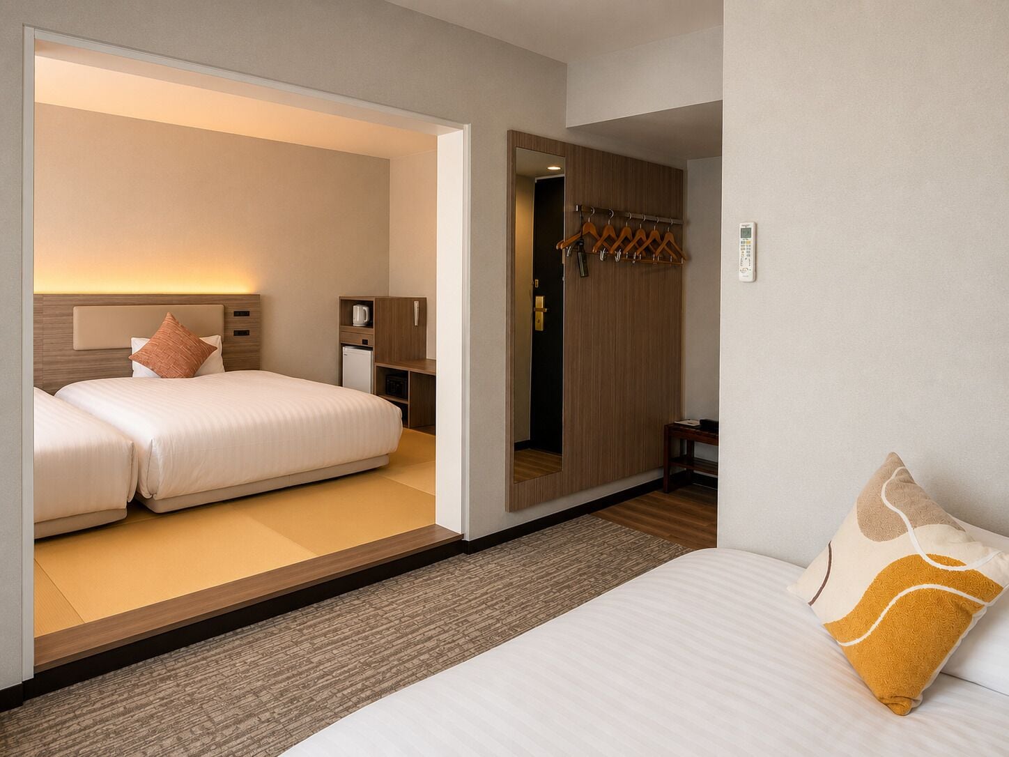 Een hotelkamer met een bed, nachtkastje, spiegel en kast.