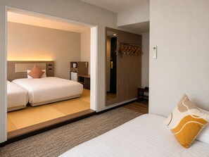 Una habitación de hotel con una cama, una mesita de noche, un armario y un espejo.