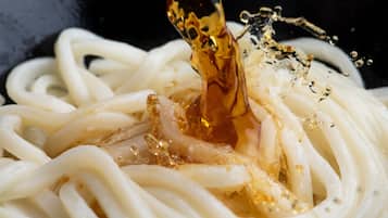 Un tazón de fideos con un líquido transparente que se está sirviendo.
