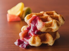 A stack of waffles with syrup.