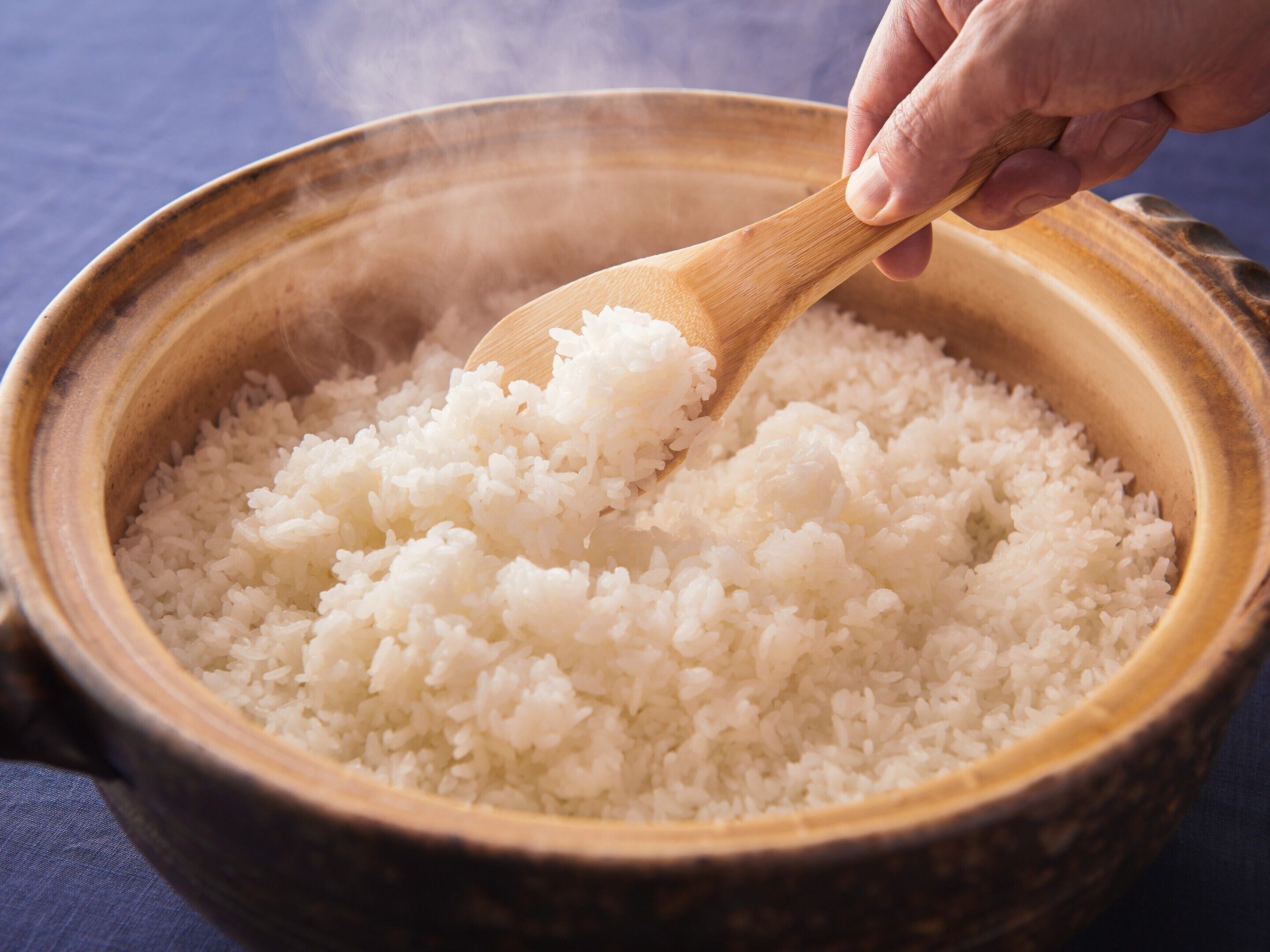A wooden bowl filled with white rice.