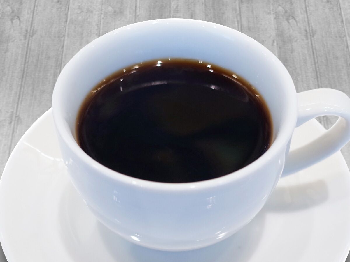 A white cup of coffee on a saucer.